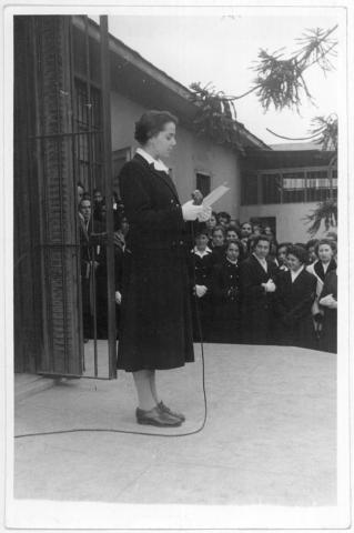 Primera imagen del registro Alumna lee en un acto